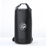 Load image into Gallery viewer, En person står på steiner ved vannet og holder en svart NEST-tørrbag med logo på.
